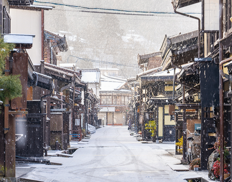 Sanmachisuji street in Takayama, lined with merchant houses on a lightly snowy day.