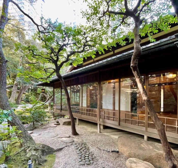The exterior of a Japanese teahouse in the woods.