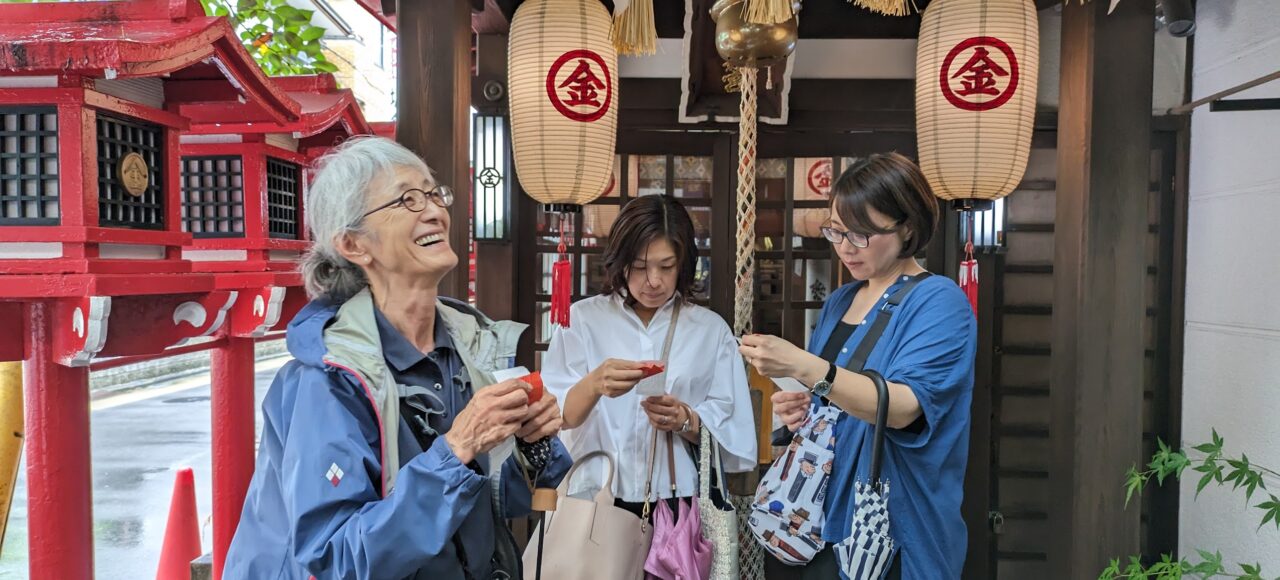 Endoji Tour 2025-09-07 Three women reading their paper fortunes at a Japanese shrine.