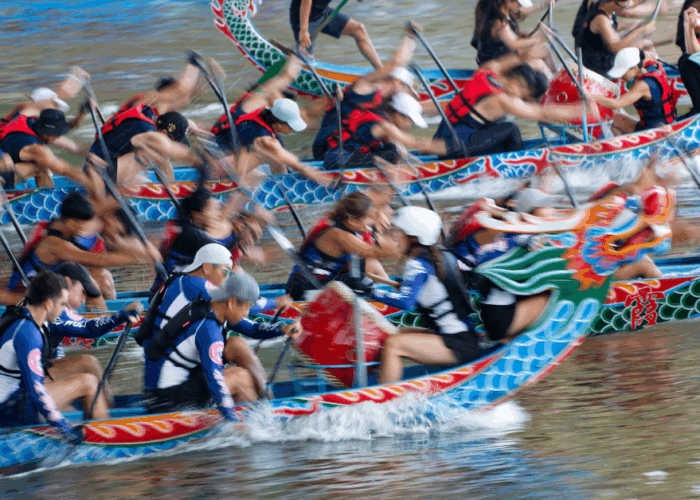 Dragon boat racing on a river with half the players in focus and half blurred.