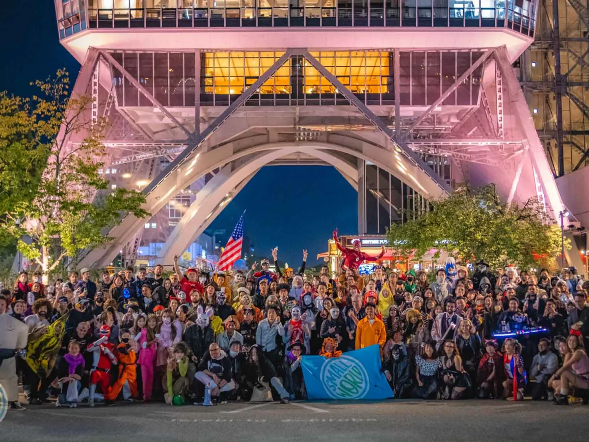 Participants dressed up in Halloween costumes stand for a picture in front of Chubu TV Tower.